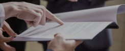 Imagem de pessoas manuseando documento para ilustrar conteúdo sobre impacto na Área tributária em 2025.